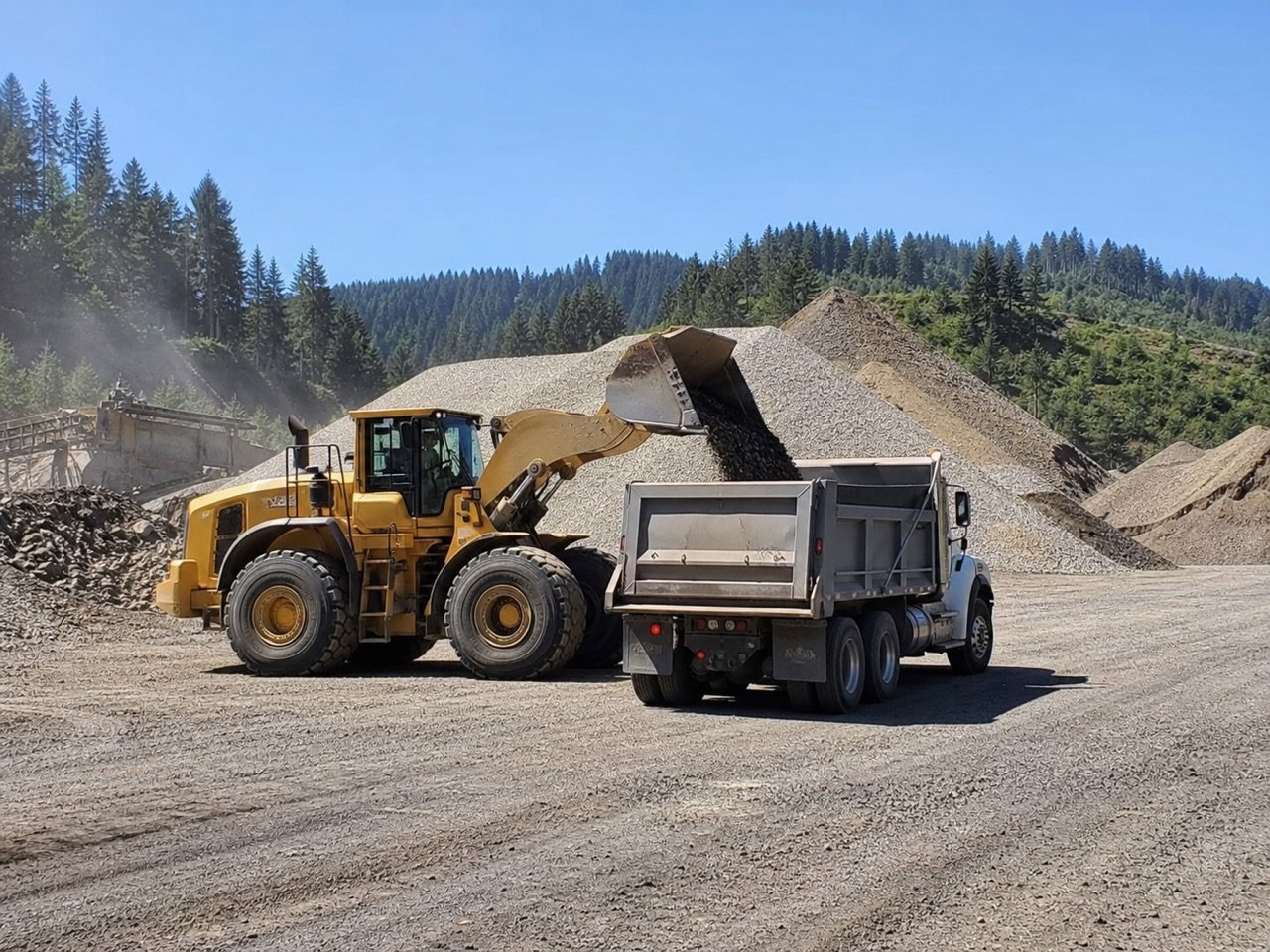 Wheel loader filling a commercial dump truck with crushed aggregate