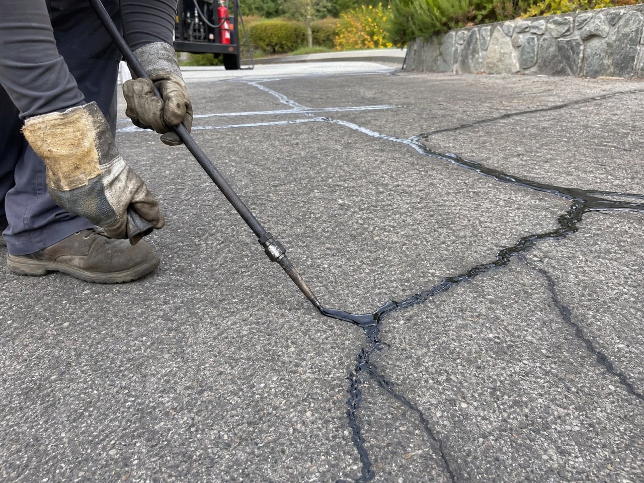 Close-up of crack sealant being applied with a heated wand